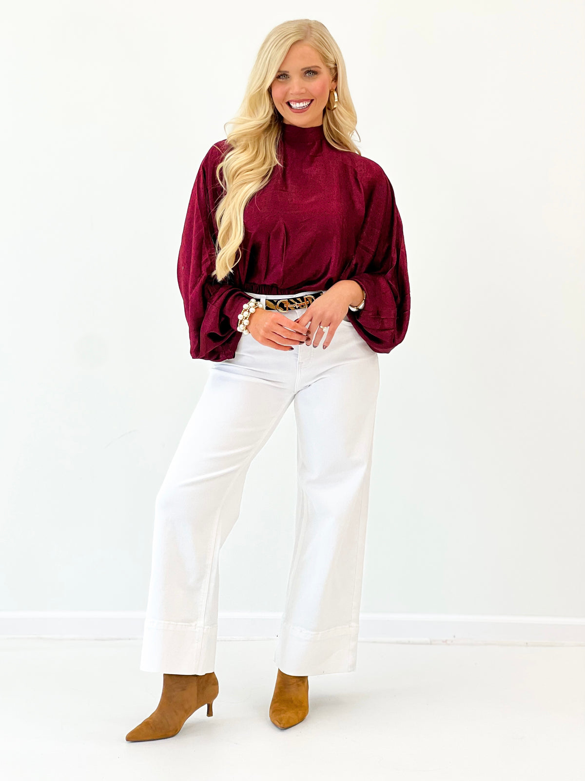 Burgundy polka dot high-neck blouse with billowy sleeves and tie-back look