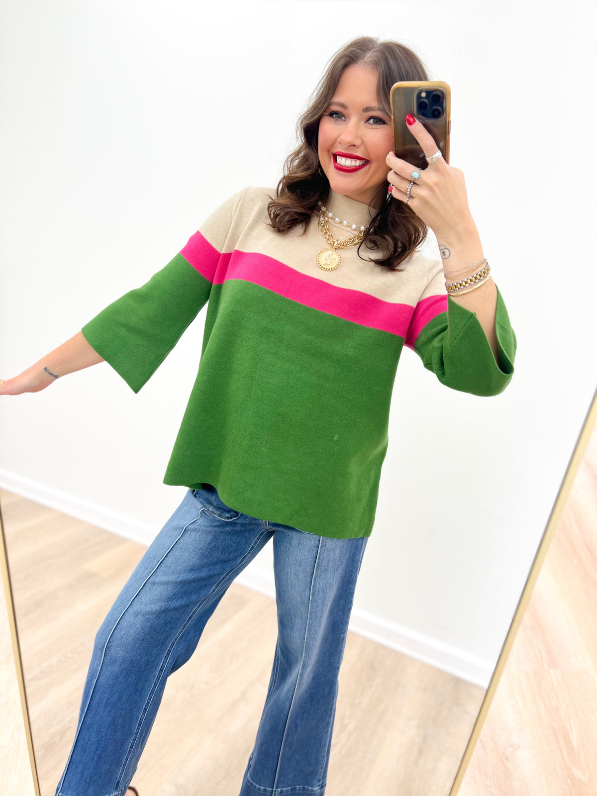 Beige and green mock neck sweater with a pink horizontal stripe