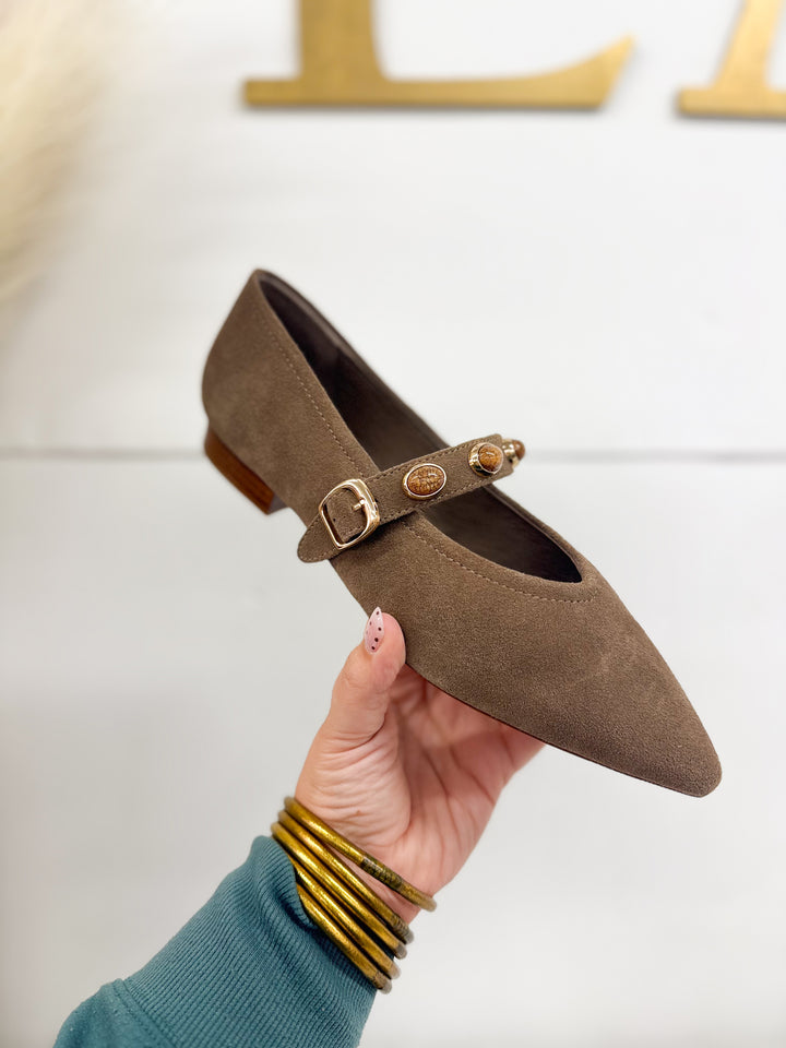 Taupe suede pointed stud flat with gold coin-stud strap and buckle, shown in hand