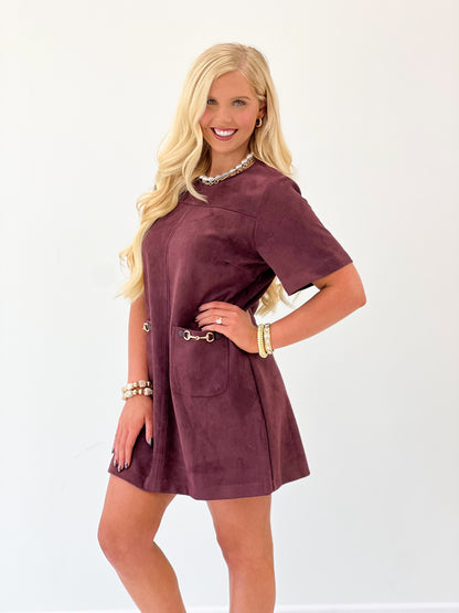 Merlot suede mini dress with short sleeves, front pockets, and gold-tone hardware detail