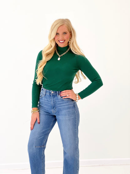 Green mockneck top with long sleeves and fitted silhouette