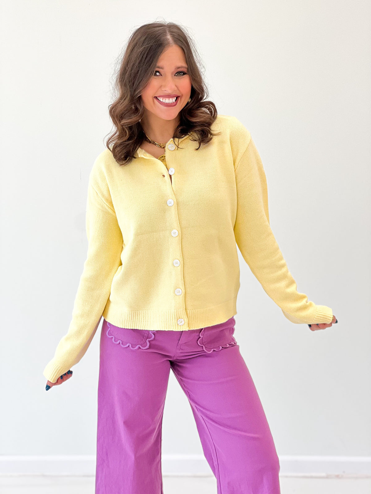 Yellow button-up cardigan with round neckline, front buttons, and long sleeves