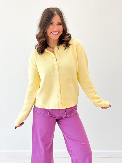Yellow button-up cardigan with round neckline, front buttons, and long sleeves