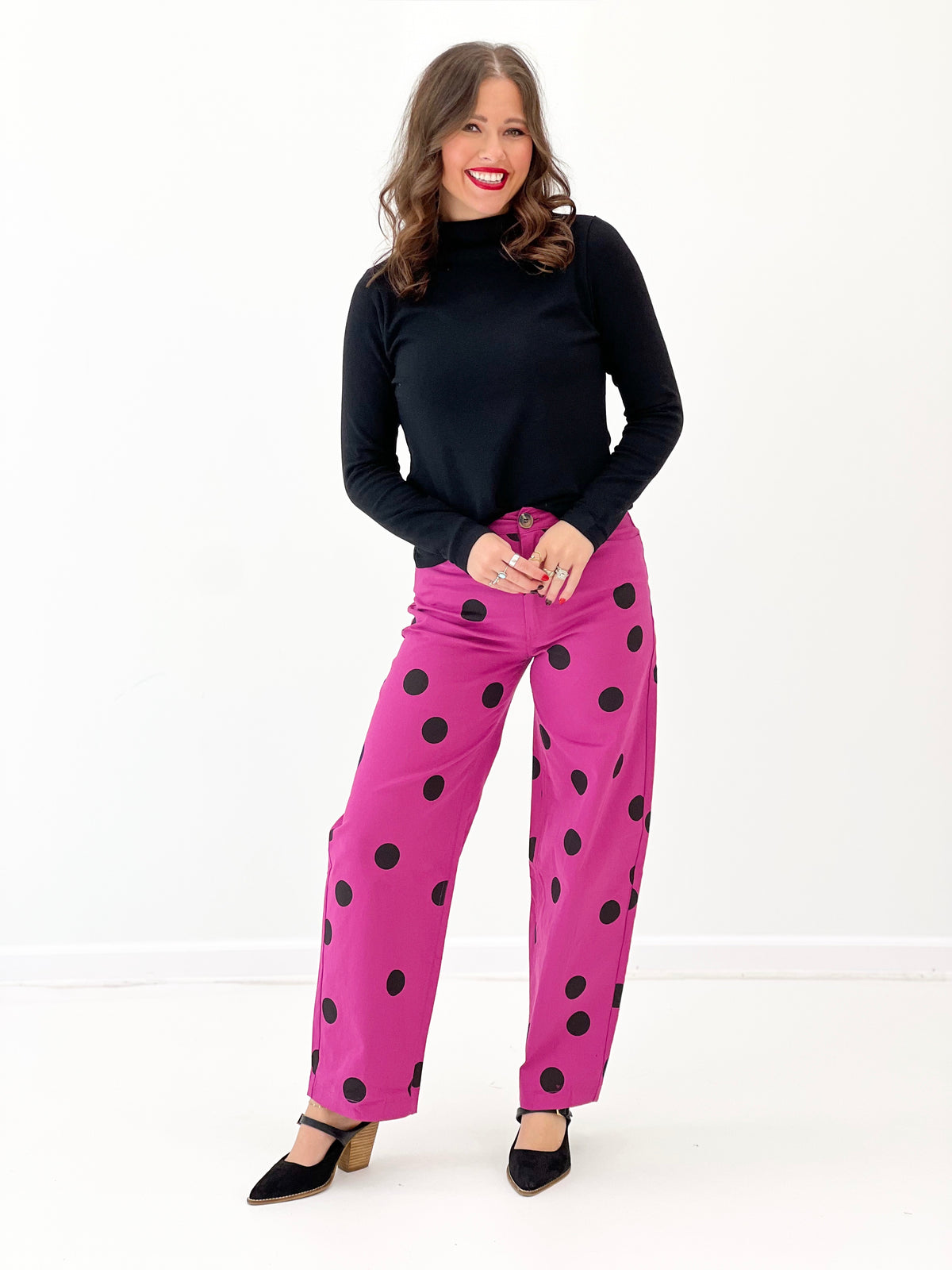 Magenta polka dot wide-leg stretch pants with black dots and buttoned front