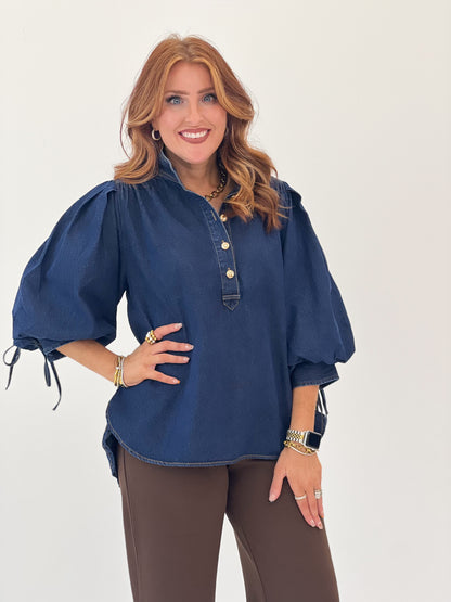 Dark denim top with puff sleeves, split neckline, and three-button placket