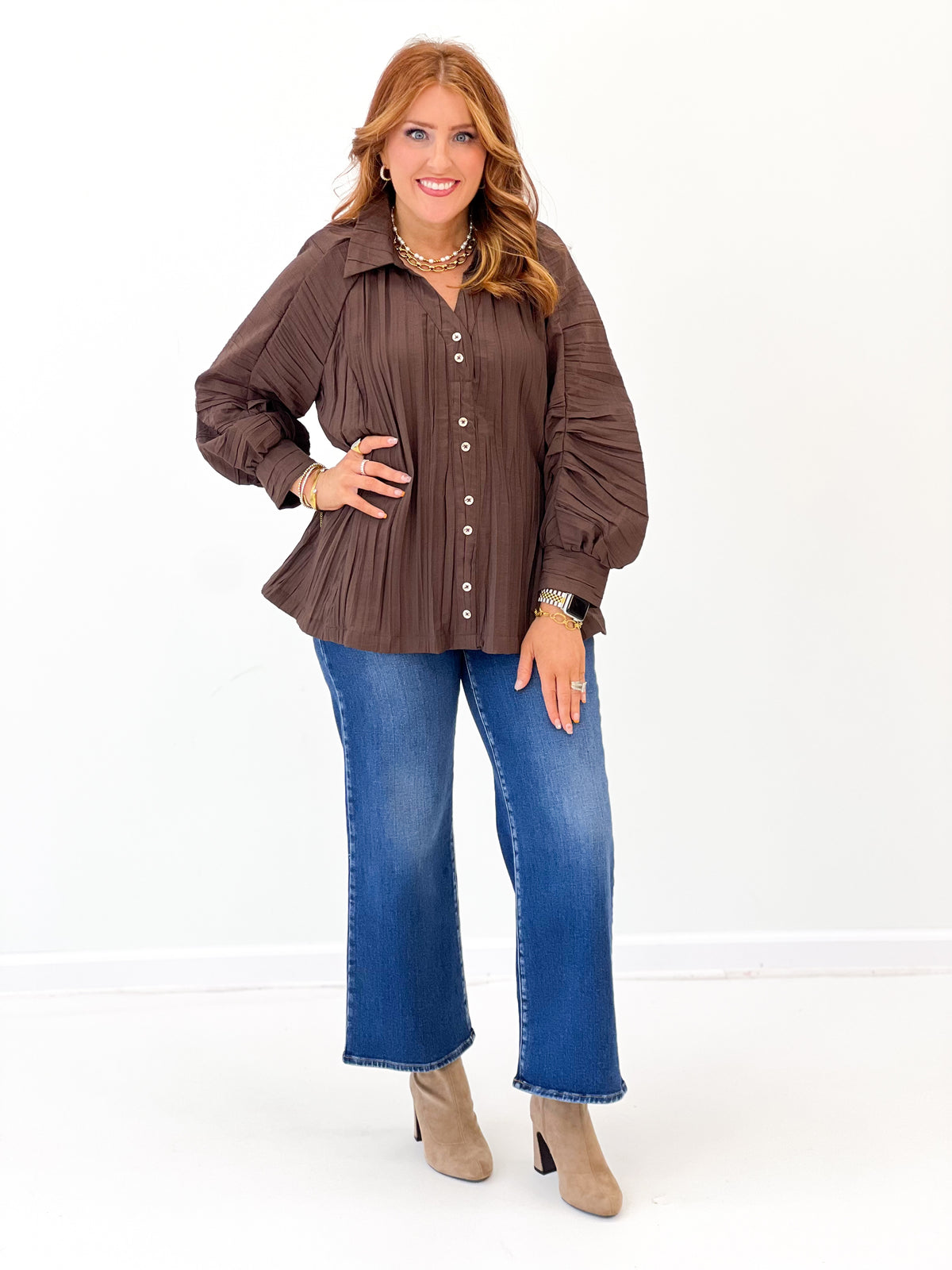 Brown ruched button-up V-neck top with button placket, long sleeves, and flared hem