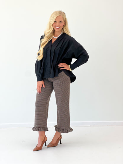 Black V-neck pleated-waist blouse with long sleeves and layered pleated front.