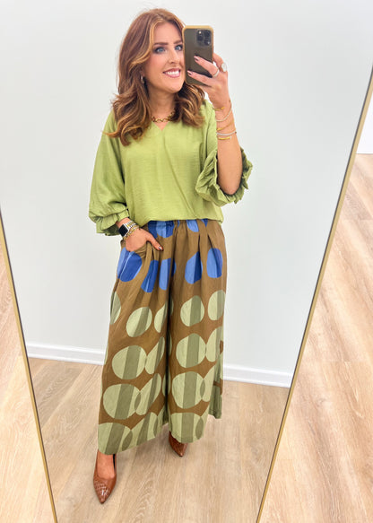 Olive mix wide-leg printed pants with oversized circular motifs and blue accent bands
