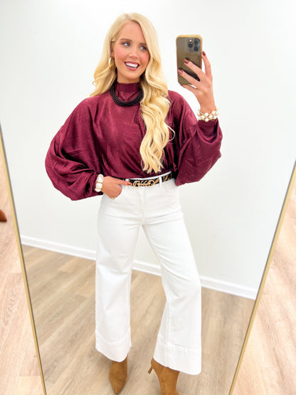 Burgundy polka dot high-neck blouse with long puff sleeves
