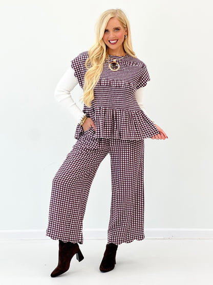 Purple-and-white gingham smocked peplum top with scalloped sleeves and round neckline ring