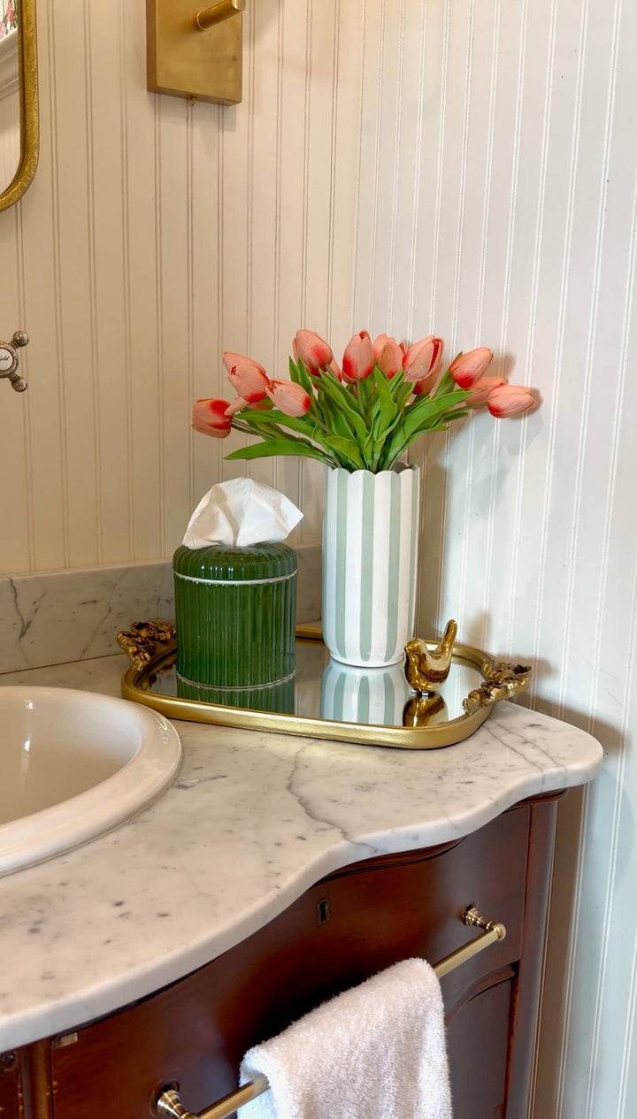 Olive green tissue holder vessel on bathroom vanity, with tissue inside
