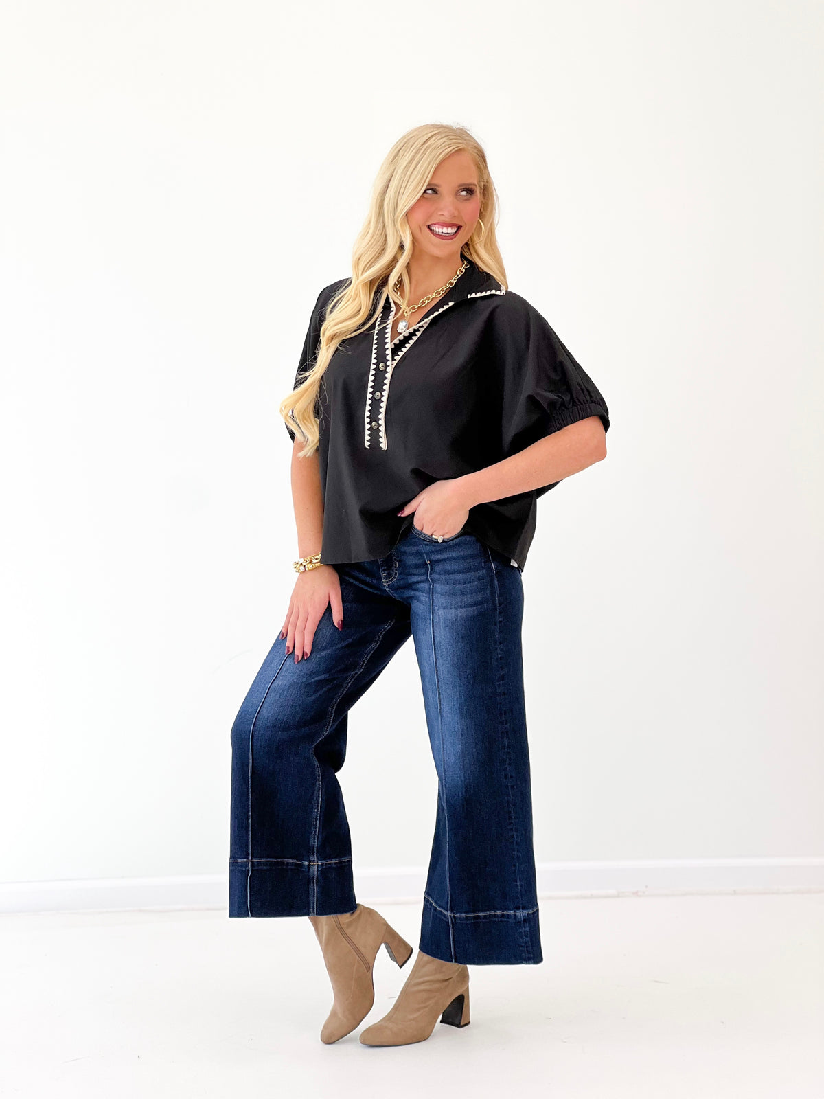 Black V-neck blouse with contrast trim and gathered short sleeves