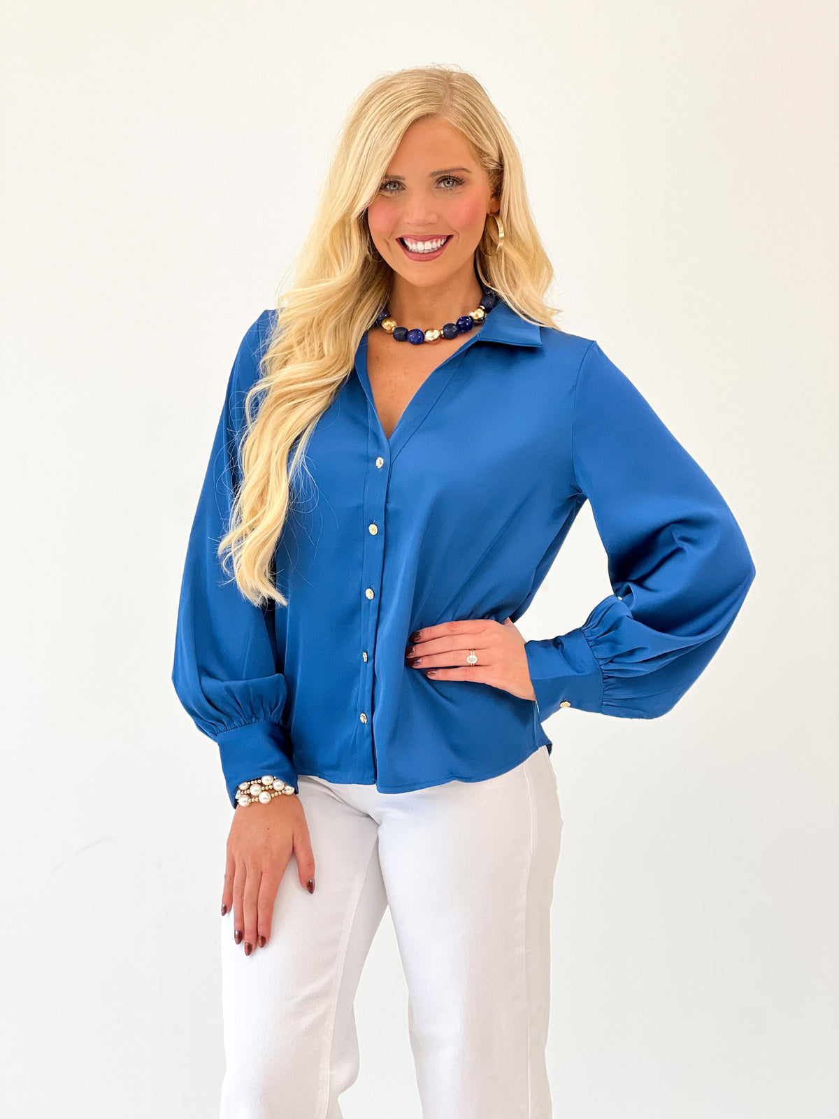 Blue satin button-up V-neck top with long sleeves and front button placket