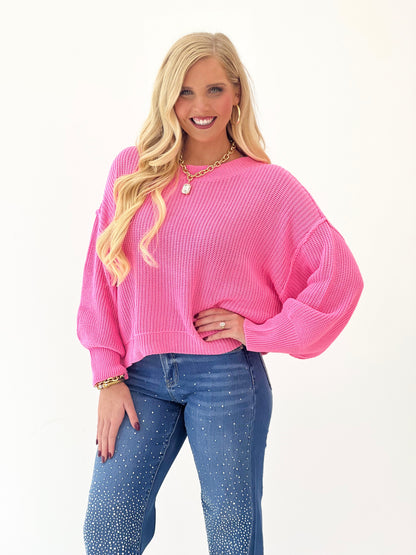 Pink oversized mock-neck sweater with long sleeves and knit texture