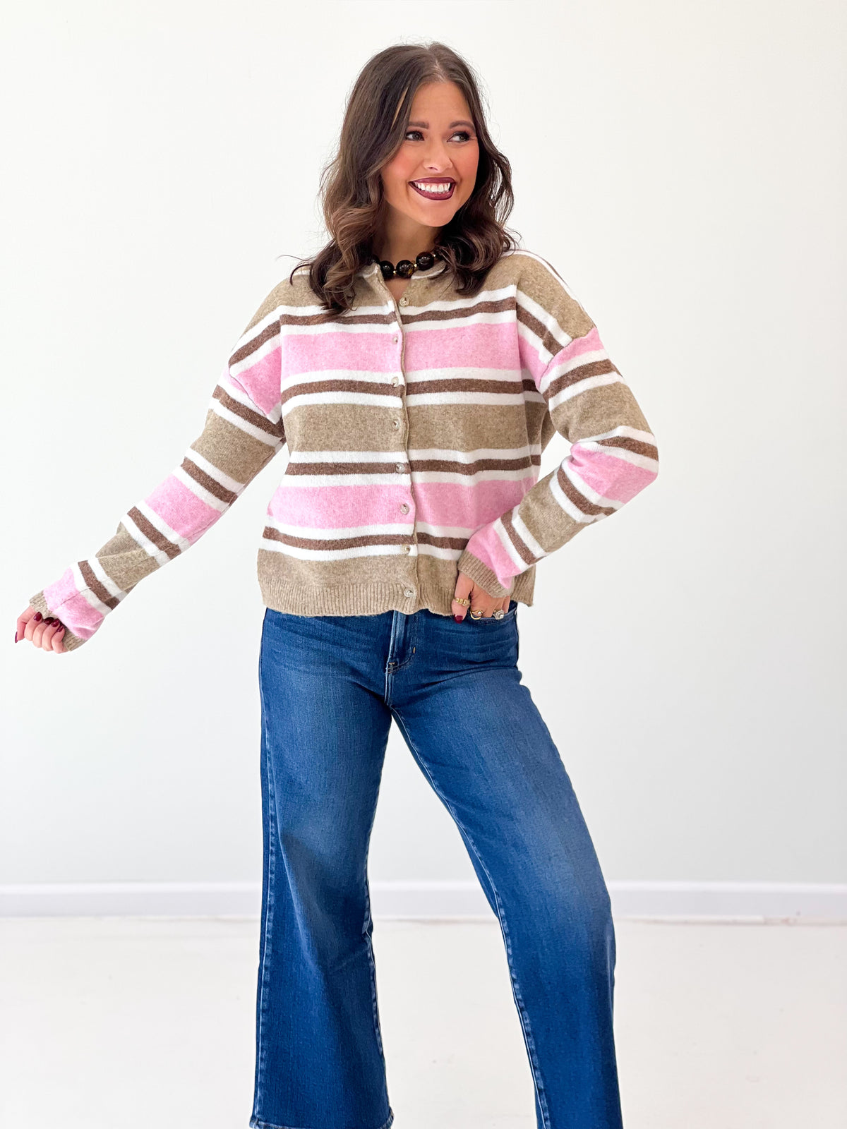 Striped button-front cardigan in muted tones with long sleeves and ribbed hem