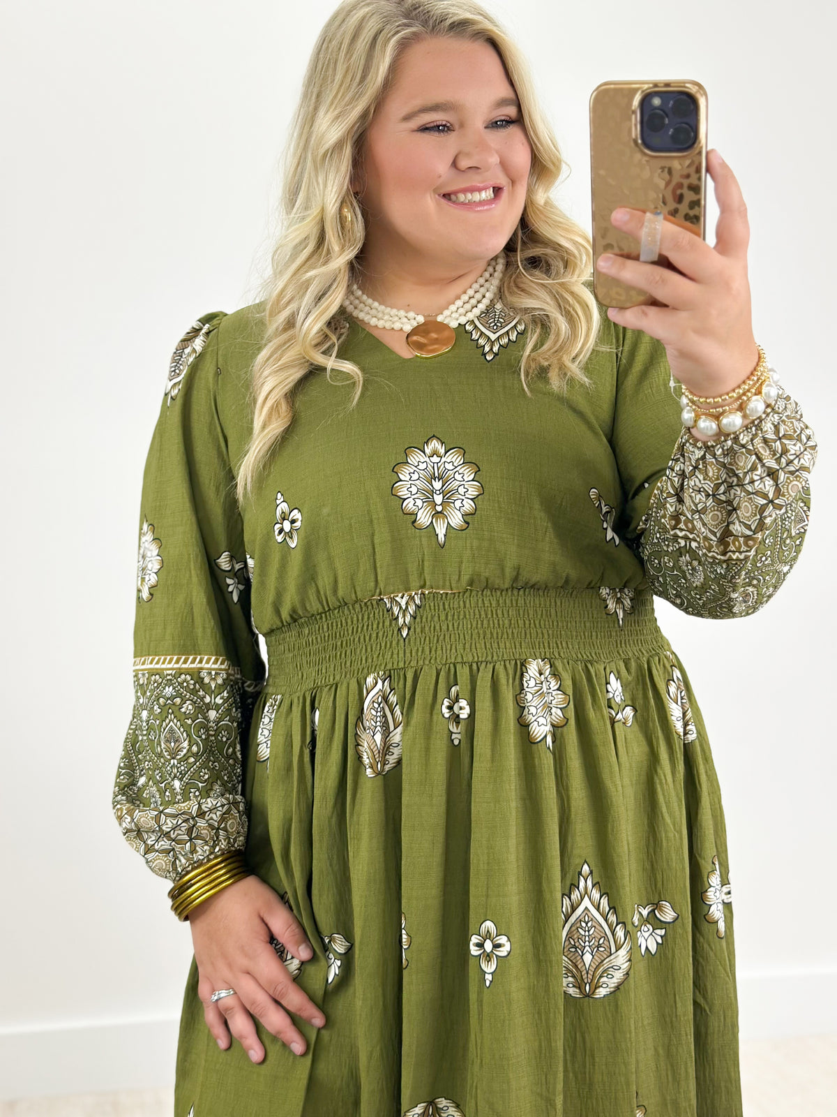 Olive green long-sleeve border print dress with patterned hem border and motif skirt