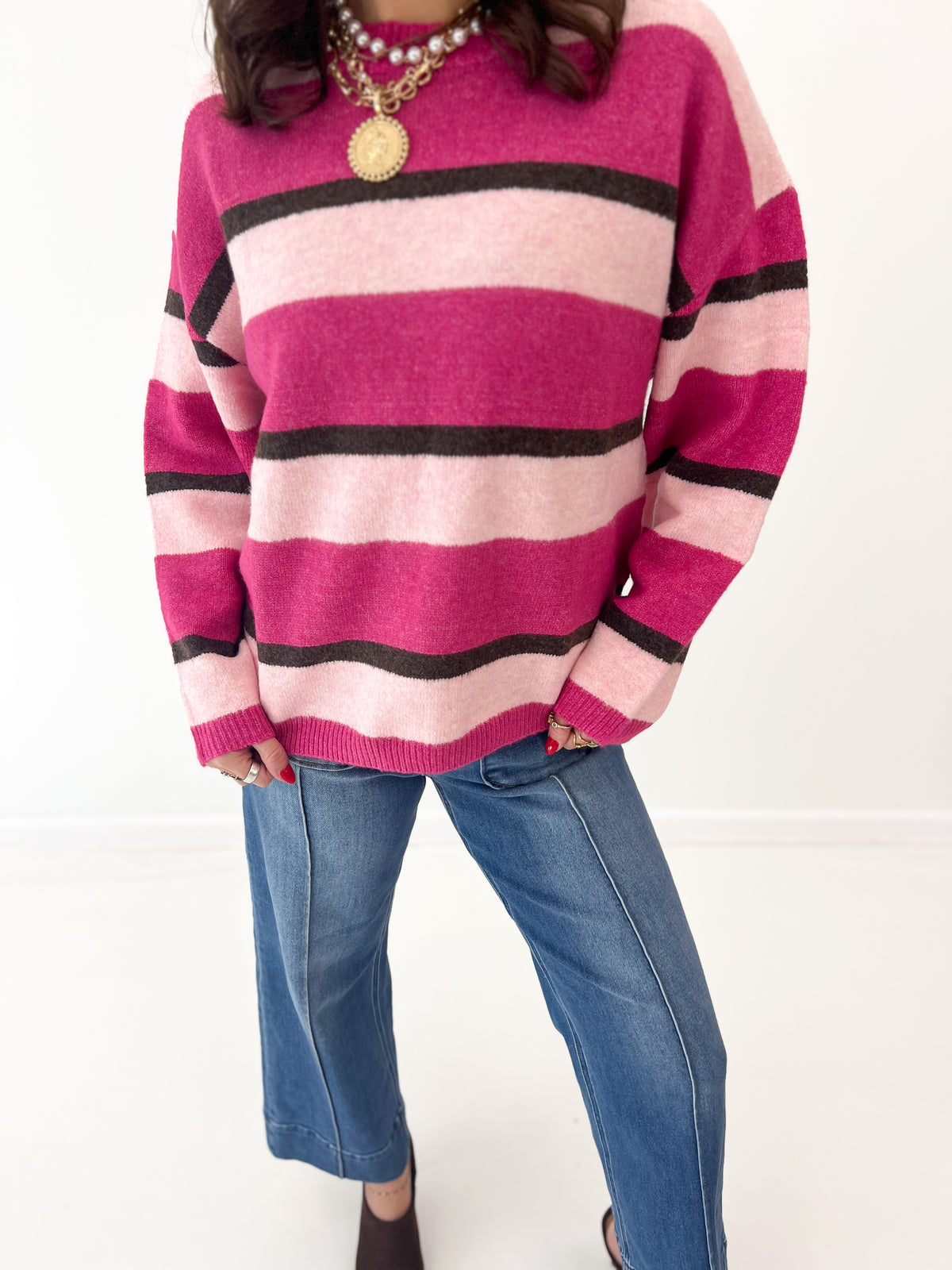 Magenta and light pink striped knit sweater top with black horizontal bands, crew neck