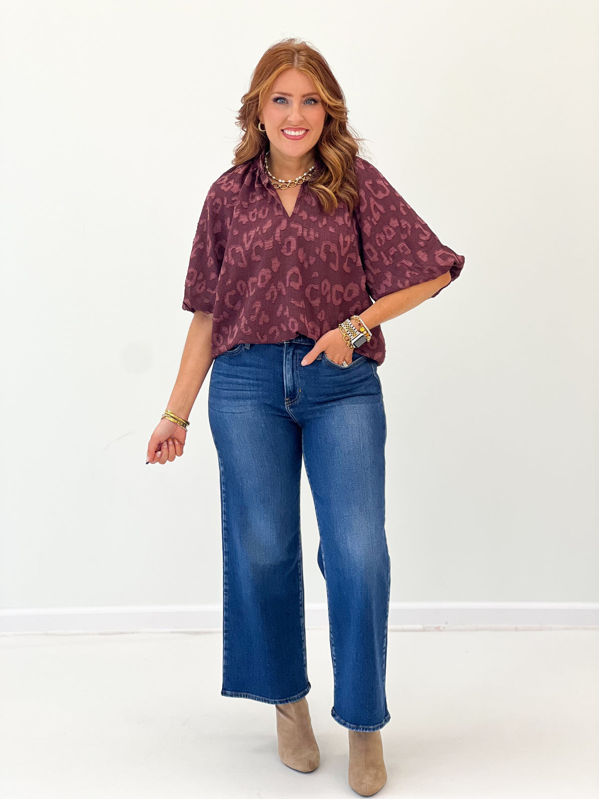 Maroon textured jacquard split-neck top with puff sleeves and allover animal print