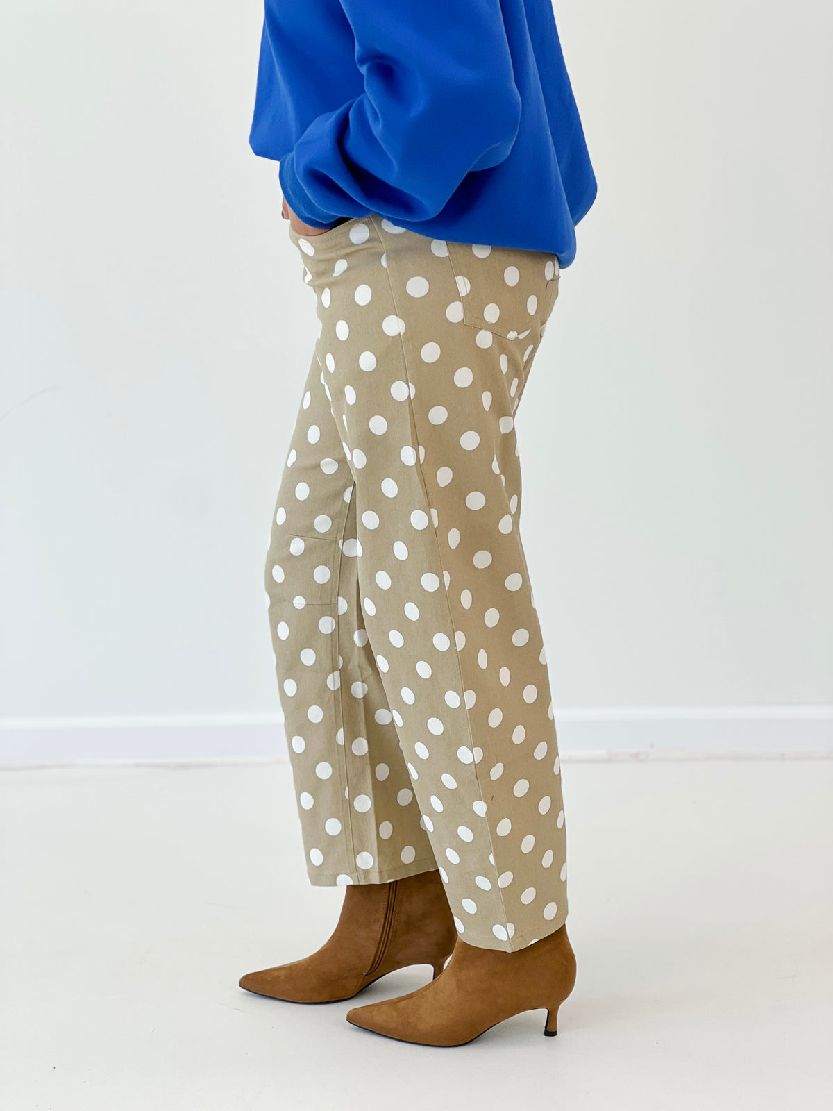 Taupe high-rise straight-leg polka dot pants with white dots, close-up leg
