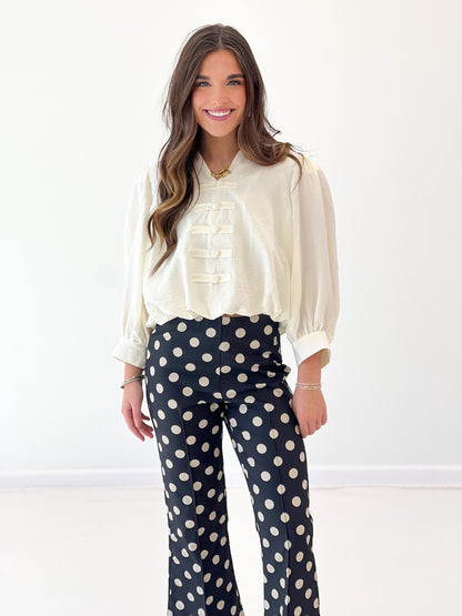 Cream long-sleeve blouse with ruffle front, puff sleeves, elastic cuffs and gathered yoke