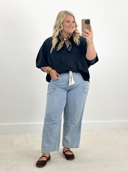 Black oversized v-neck top with cuffed batwing sleeves, flowing hem
