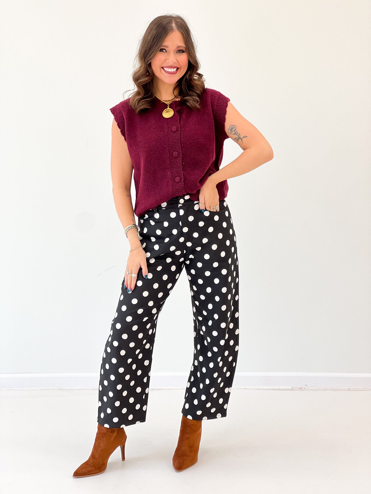 Burgundy ribbed button-up sweater vest with scalloped edges and gold-tone button center