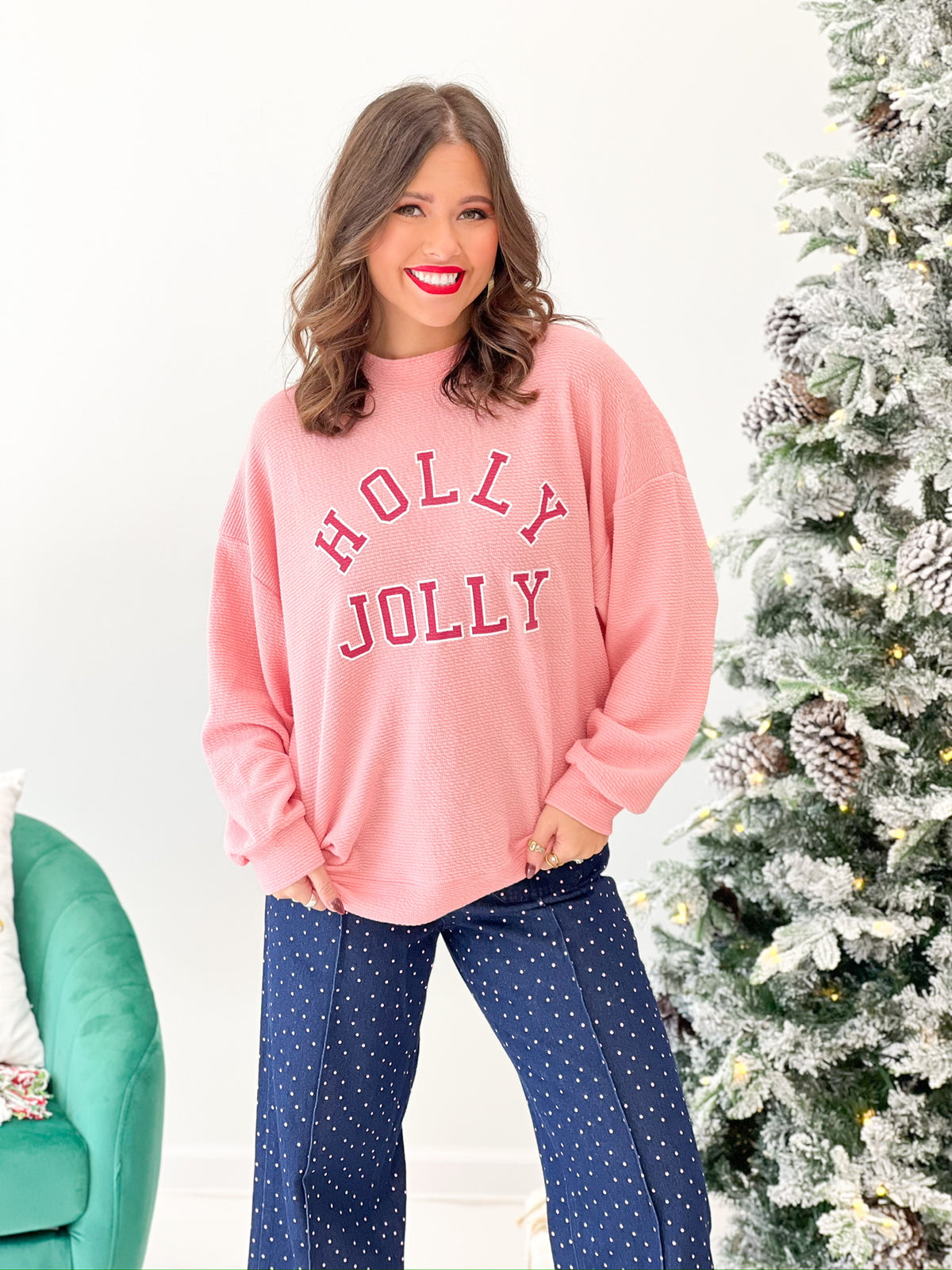 Pink knit Christmas sweatshirt with 'HOLLY JOLLY' graphic, crew neckline