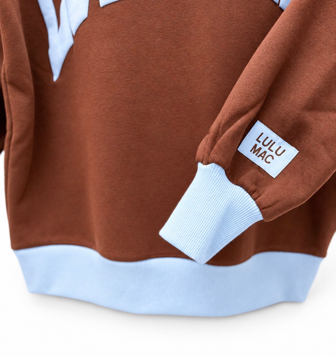 Brown sweatshirt with light blue ribbed mock neck and cuffs, sleeve logo patch