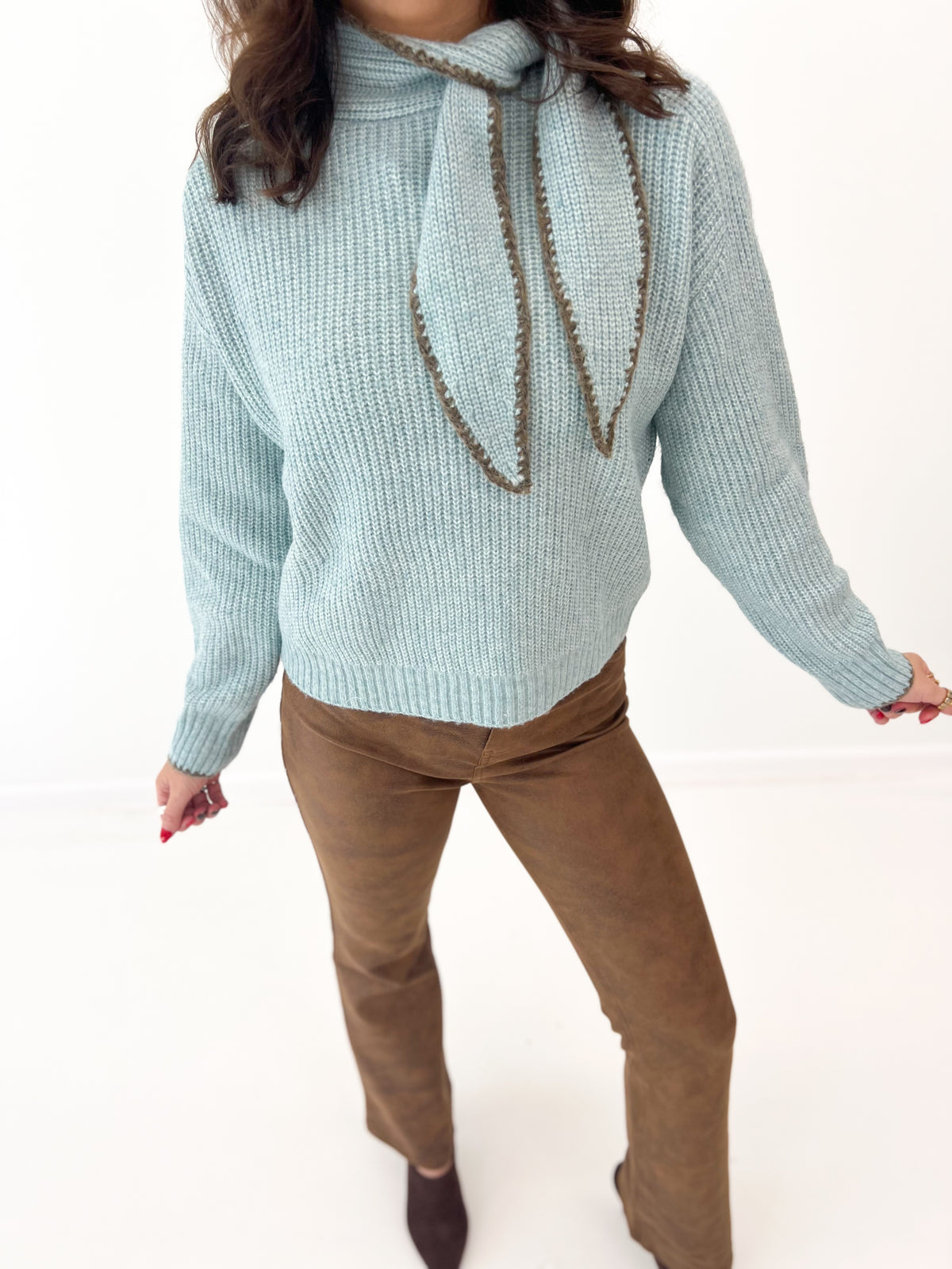 Dusty mint knit sweater with scarf-stitch detail and draped cord tie at neck
