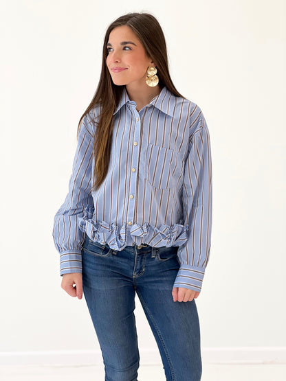 Women's blue striped long-sleeve button-front top with pointed collar and ruffle hem