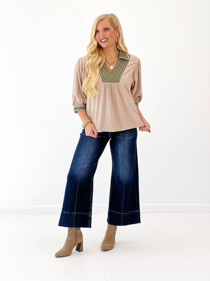 Stone linen blouse with green-trimmed V-neck and loose puff sleeves