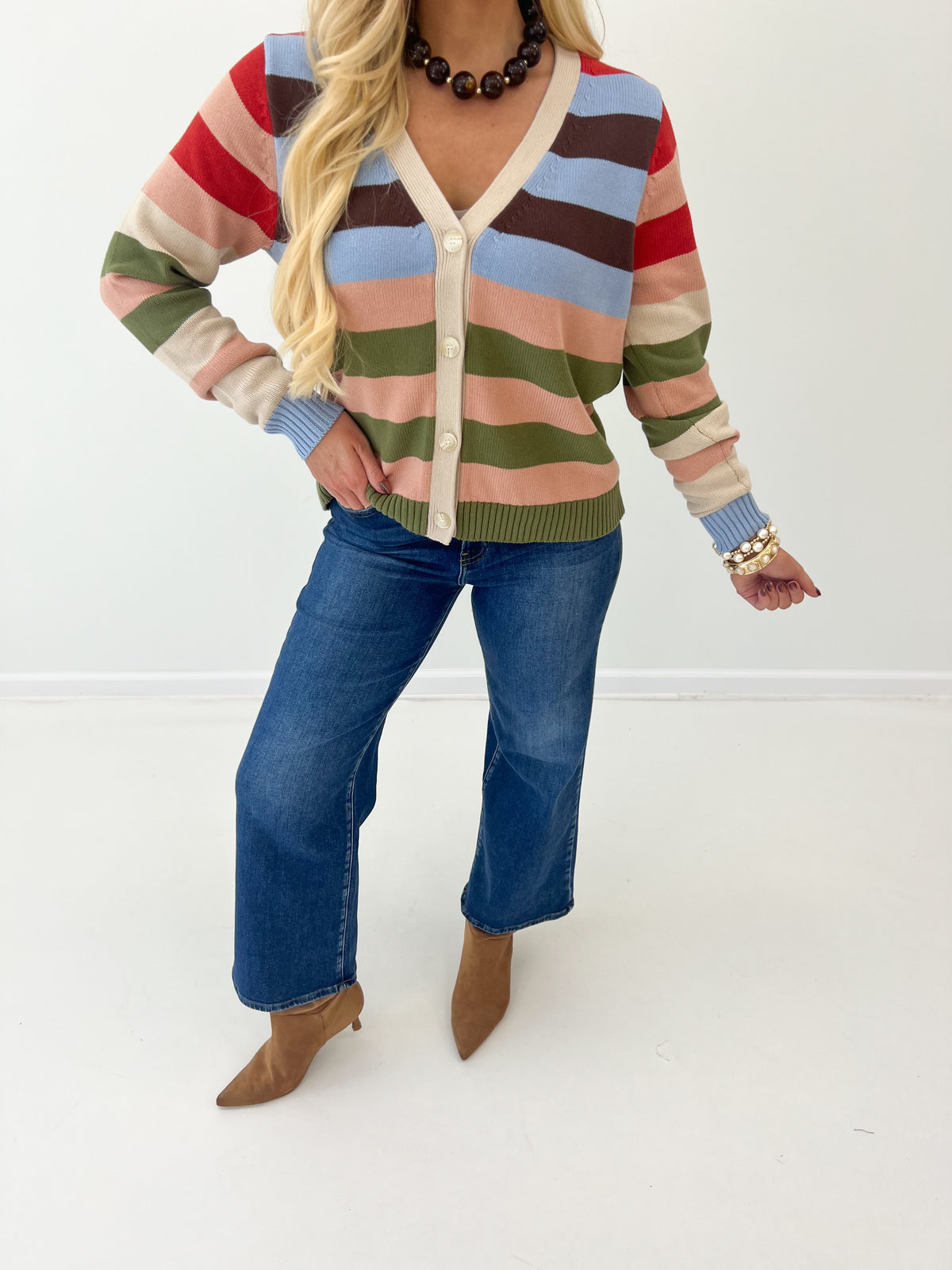 Close-up of beige multi striped v-neck button cardigan with long sleeves and ribbed cuffs