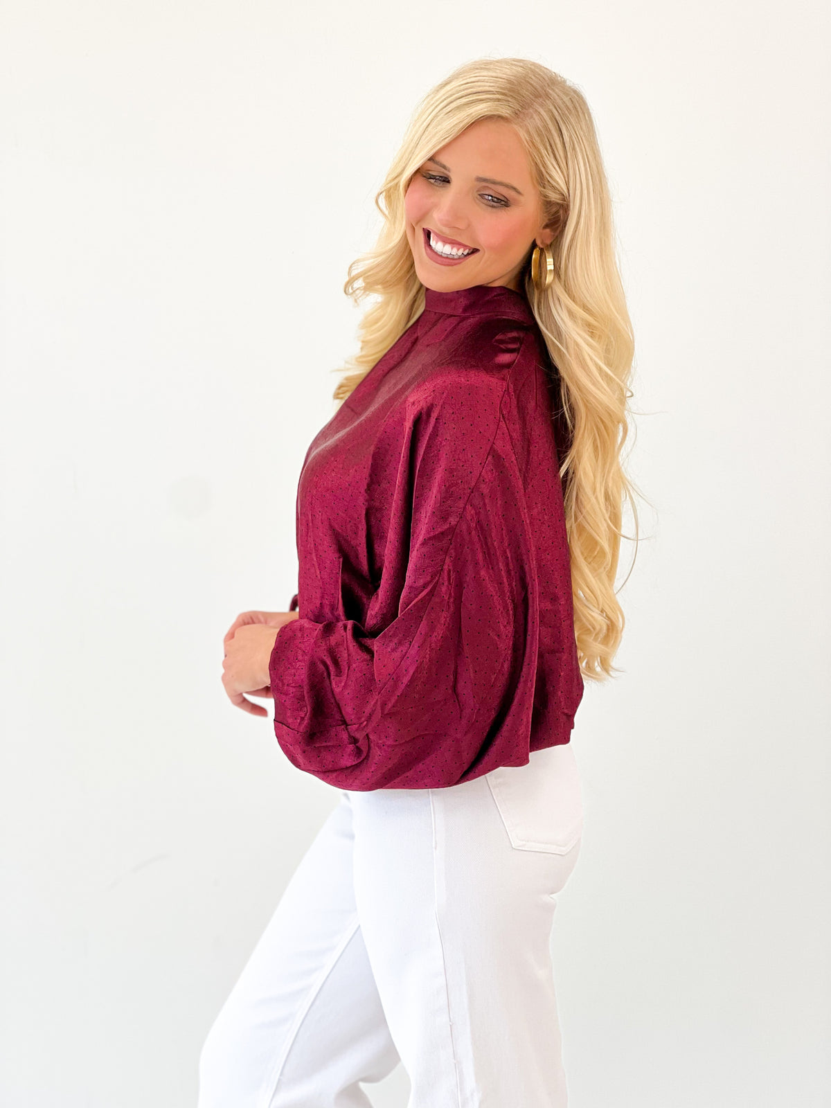Burgundy polka dot high-neck blouse with tie-back detail and puff sleeves