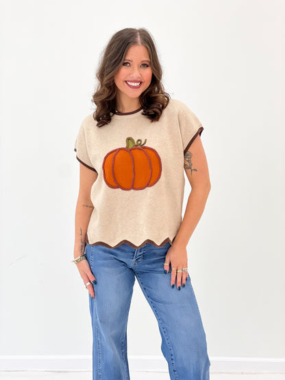 Light taupe crewneck sweater top with orange pumpkin applique and scalloped hem