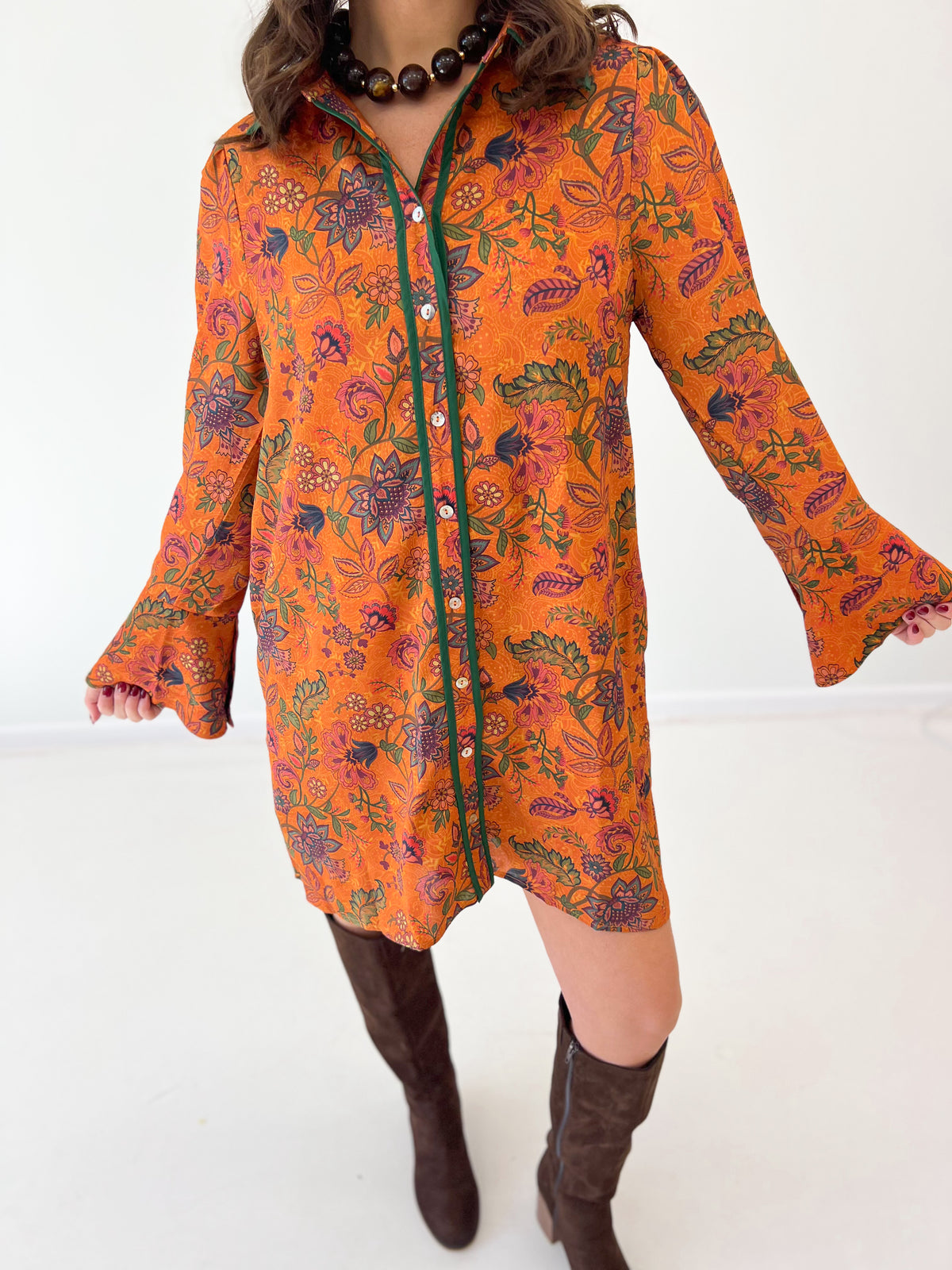 Orange floral button dress close-up with dark front placket and flared sleeves