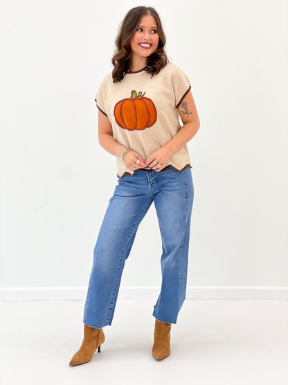 Light taupe pumpkin sweater top with short sleeves and scallop hem; worn with jeans
