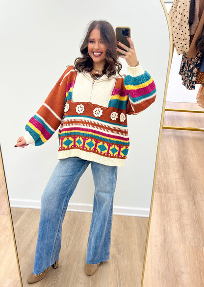 Brick multi hooded half-zip sweater with bold color blocks, striped yoke, and patterned hem