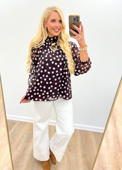 Black polka dot high-neck long-sleeve blouse with circular keyhole front detail