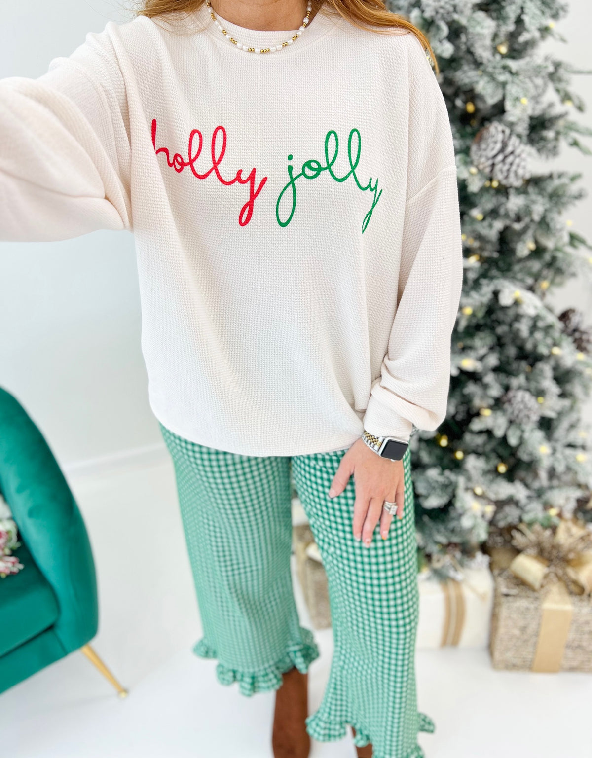 Cream knit long-sleeve Christmas top with “holly jolly” script graphic on the chest
