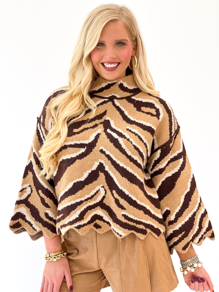 Animal print mock neck knit top with scalloped trim and relaxed dolman sleeves