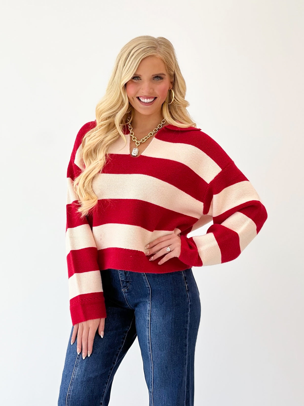 Red and ivory striped V-neck sweater with long sleeves and ribbed hem