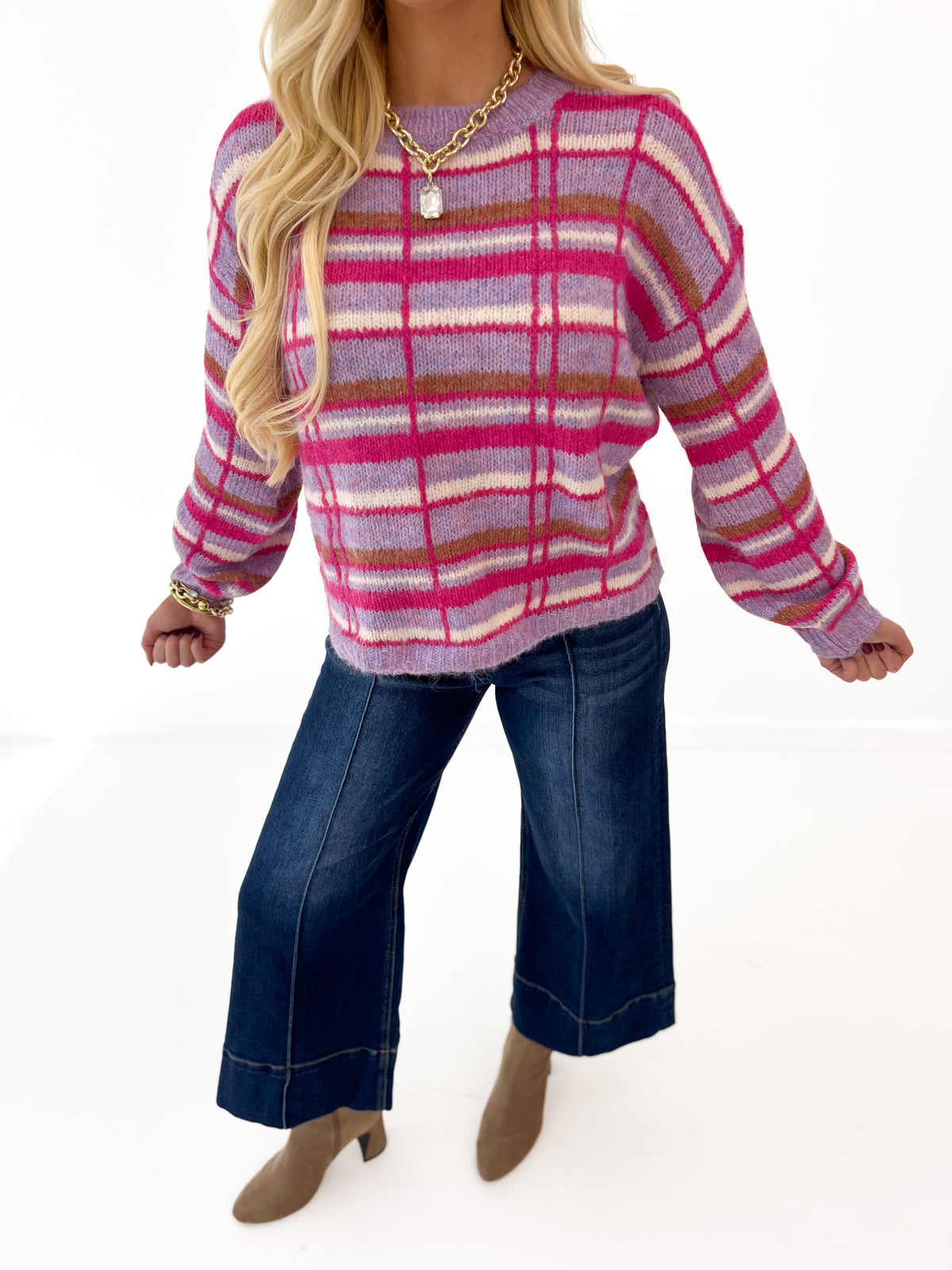 Plaid crew neck sweater with long sleeves and pink, fuchsia, and cream stripes