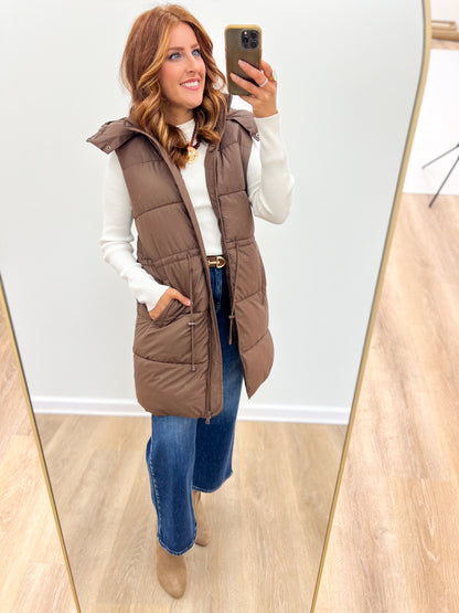 Brown longline quilted puffer vest with hooded collar and zip front