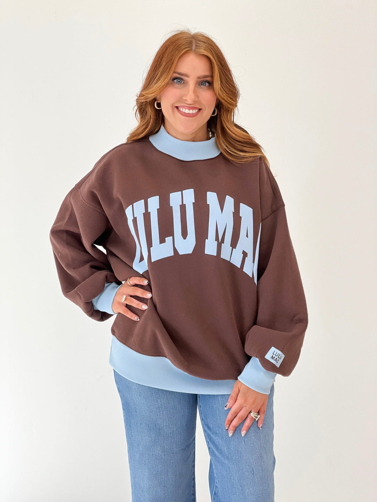 LuLu Mac brown puff mock neck sweatshirt with white “LULU MAC” graphic and light blue collar