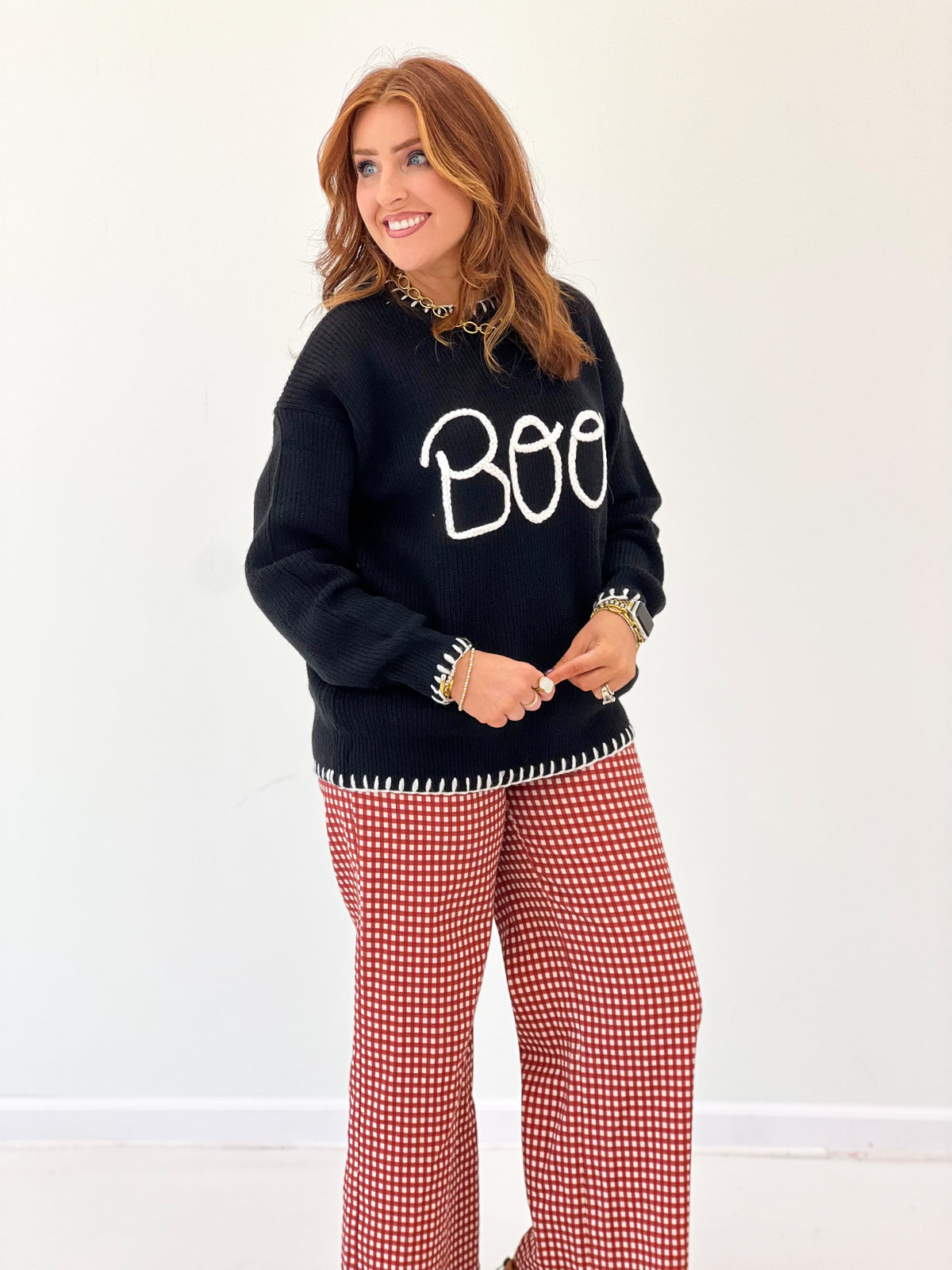 Black Boo graphic sweater with white lettering and striped trim at hem
