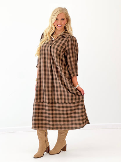 Brown-and-black checkered midi dress with open collar and softly gathered hem