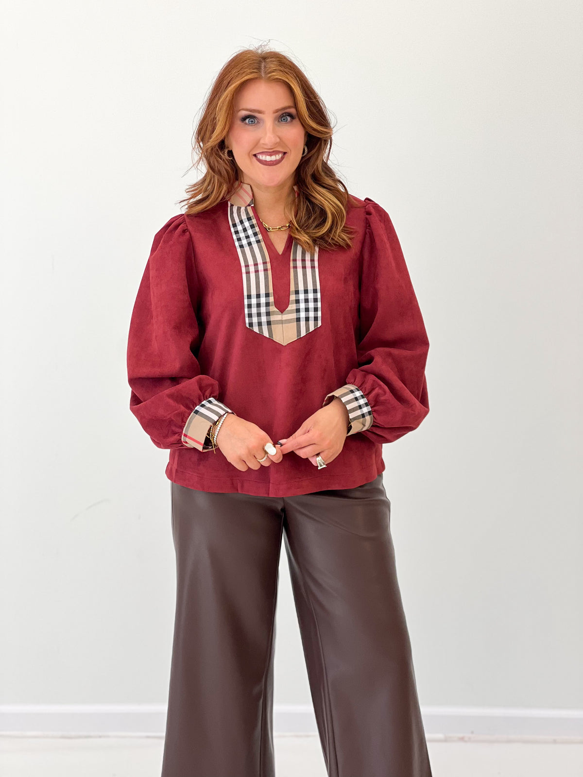 Burgundy faux suede puff-sleeve top with plaid-trim V neckline and cuffed sleeves