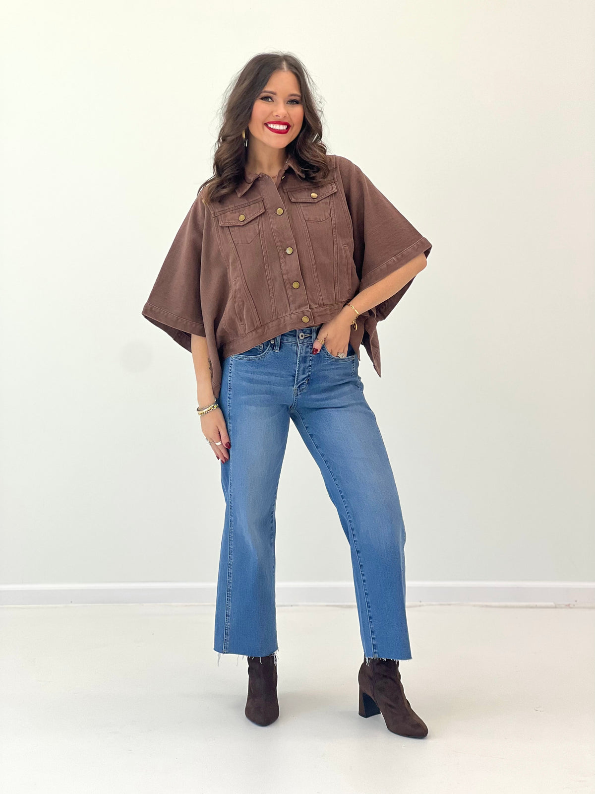 Brown short-sleeve snap-button denim jacket with chest flap pockets and brass-tone buttons
