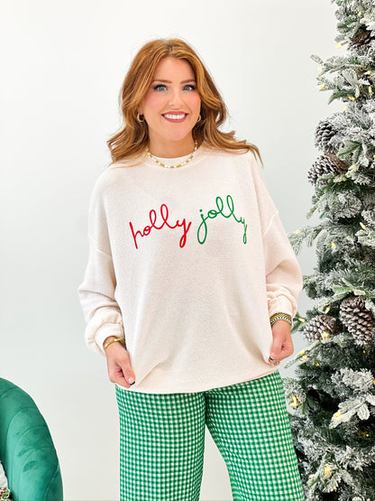 Cream knit long-sleeve Christmas top with “holly jolly” holiday script graphic