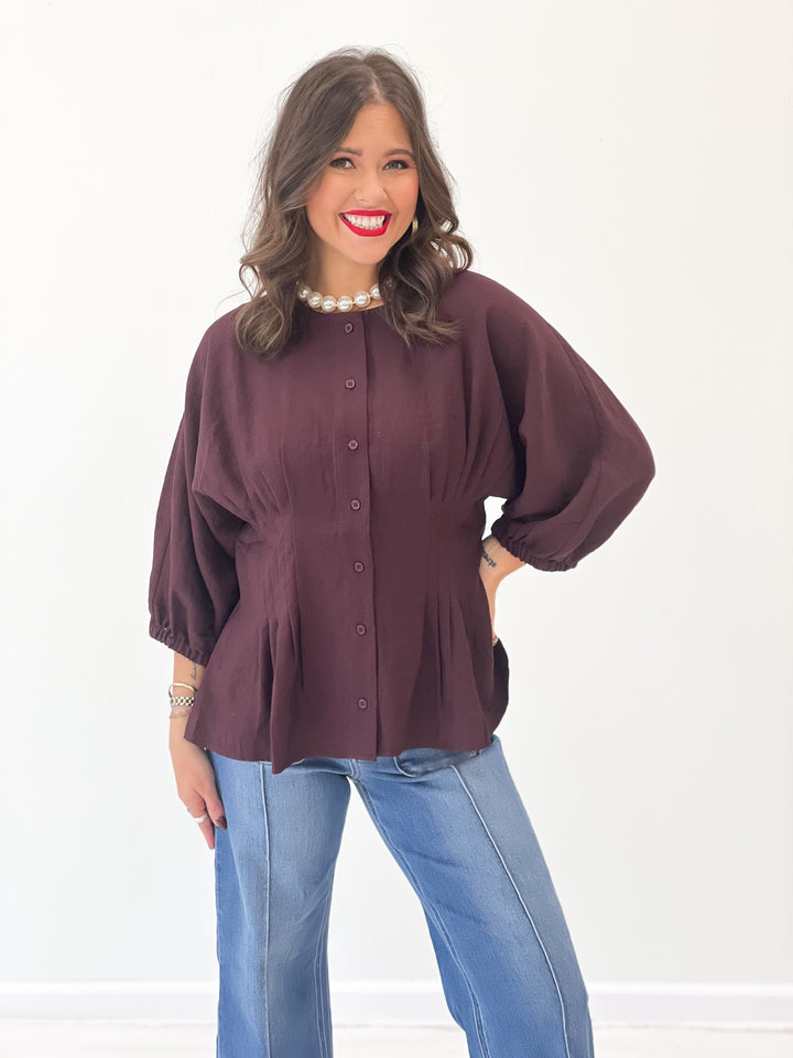 Dark maroon button-up blouse with puff sleeves and cinched waist detail